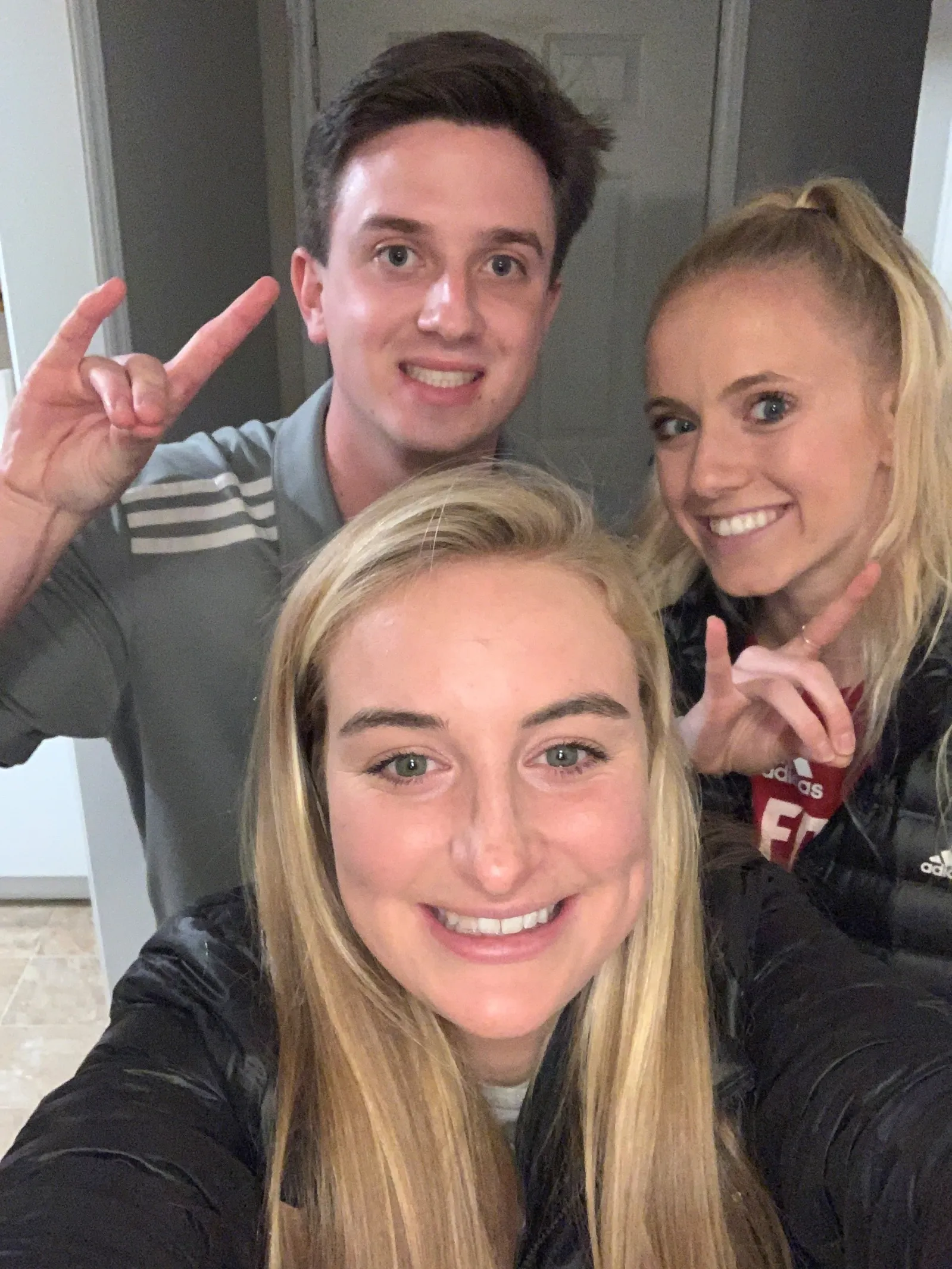 Three college age students posing in front of comera