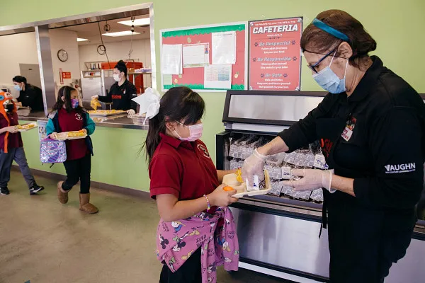 Woman giving tray of breakfast to girl