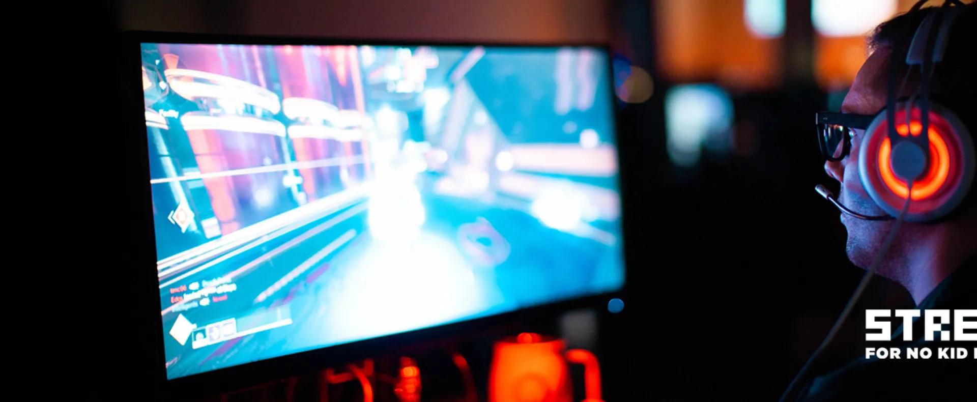 Man sitting in front of a computer monitor playing video games