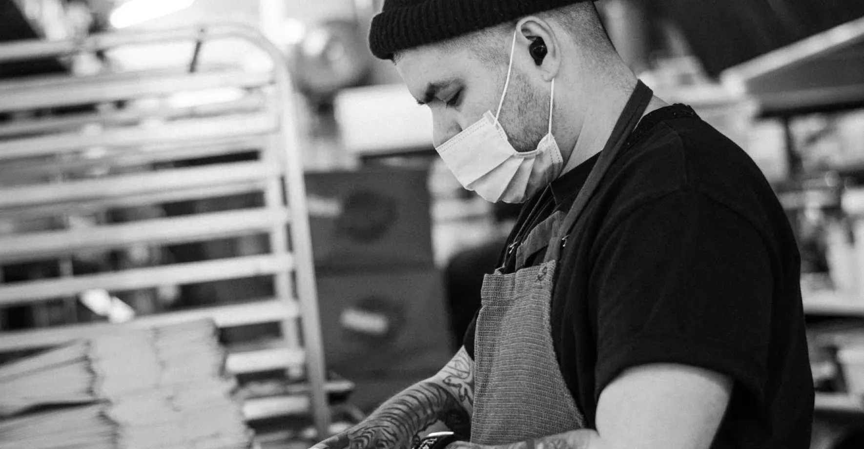 Black and white picture of chef with mask cooking a meal