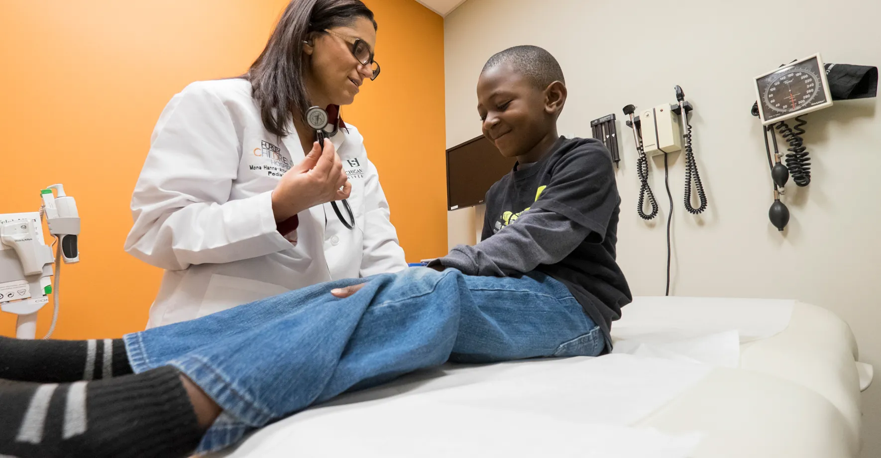 Picture of female doctor helping a young child. Both of them are smiling