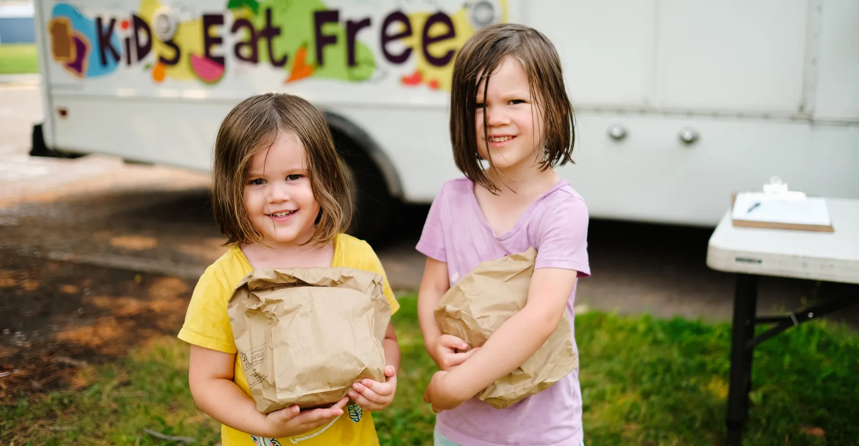 Girls holding paper bags full of food