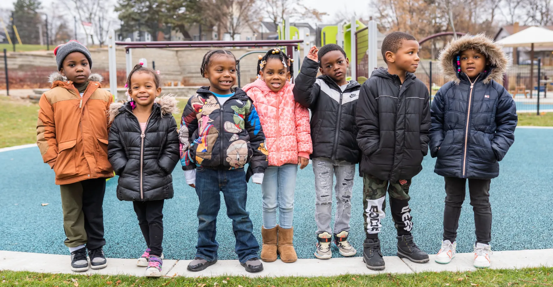 Row of young children in coats on playground