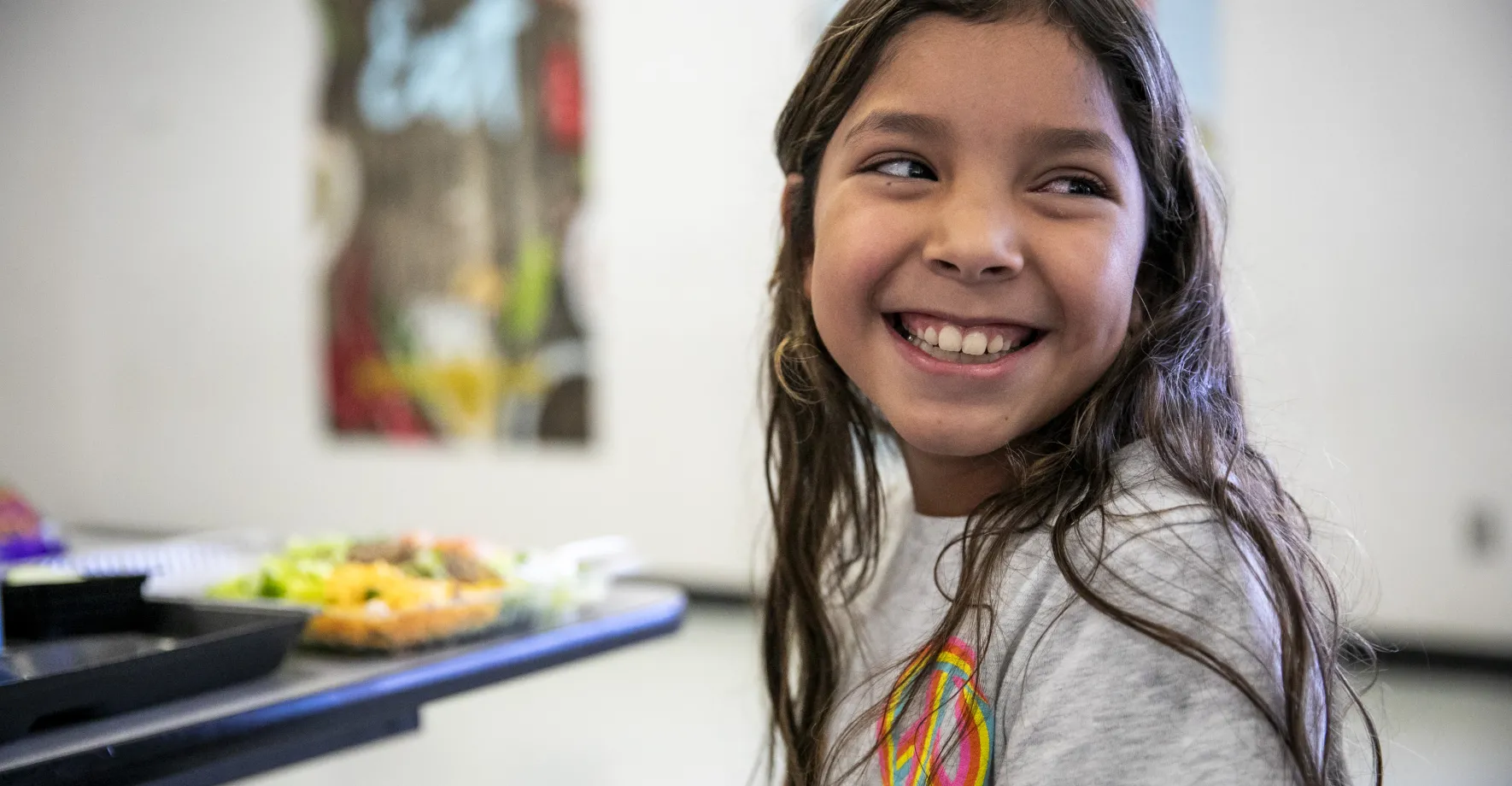 Girl smiling and looking to the right of the screen