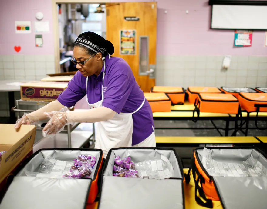 A cafeteria worker preparing breakfast