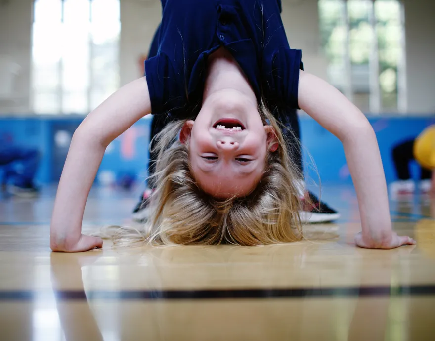 A little girl doing a headstand