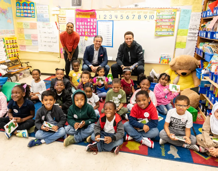 Basketball star Stephen Curry sits with a class of elementary school students.