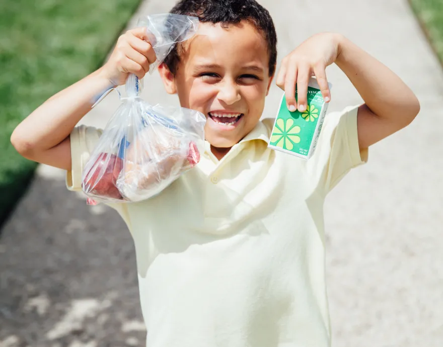 Happy boy holding bags of food