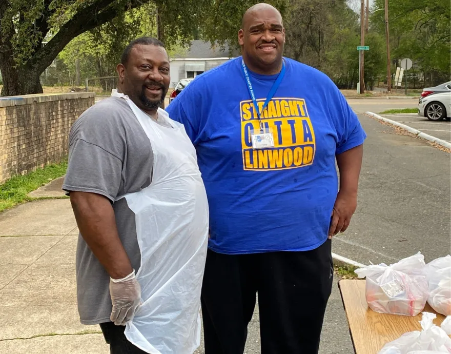 Two teachers posing for photo at food distribution center