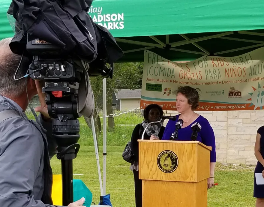 Photo of woman speaking behind podium