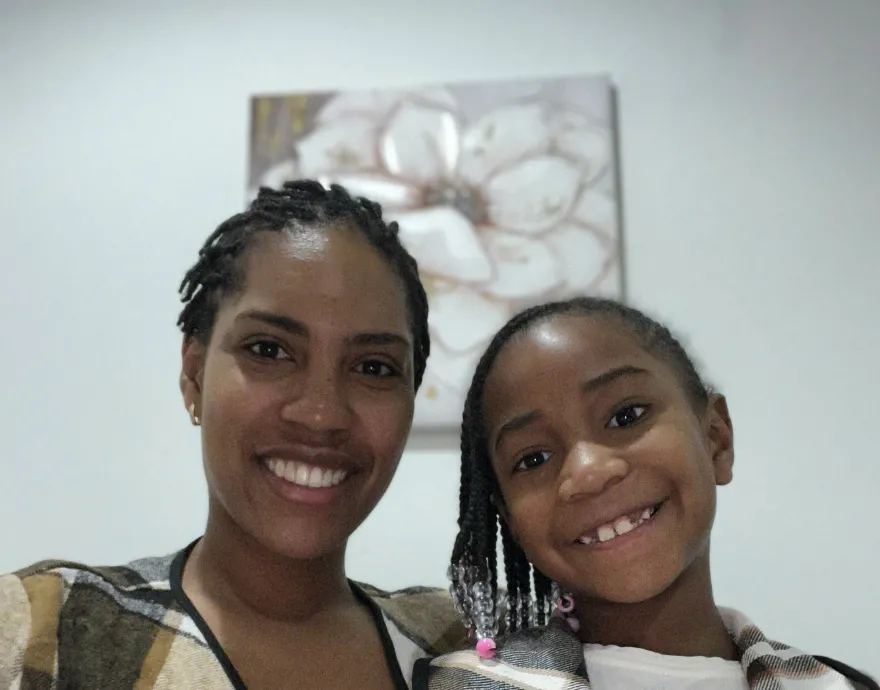 Mom and daughter dressed the same with brown and white jacket