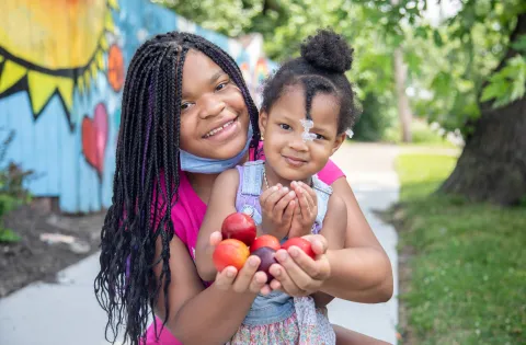 Black Mother and Daughter with Masks and Apples in Michigan