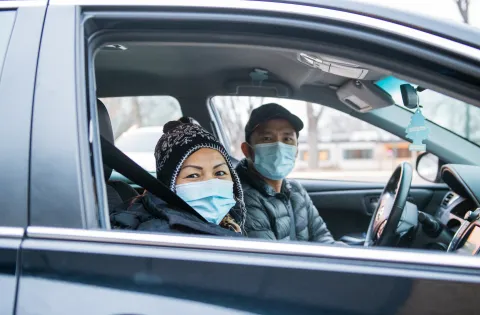 Two masked people in vehicle