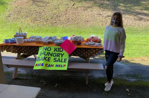 Girl wearing mask at bake sale charity event
