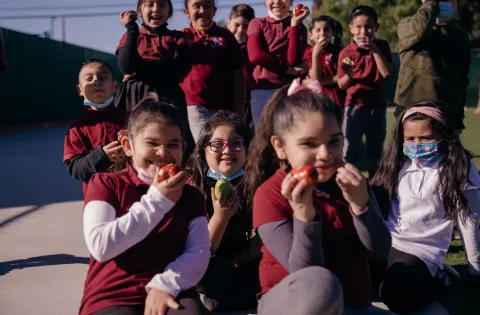 Kids eating apples and smiling