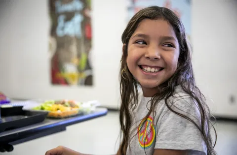 Girl smiling and looking to the right of the screen