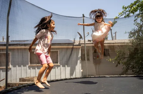 Two girls jumping in trampoline