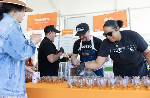 Woman serving food and wearing Sysco shirt