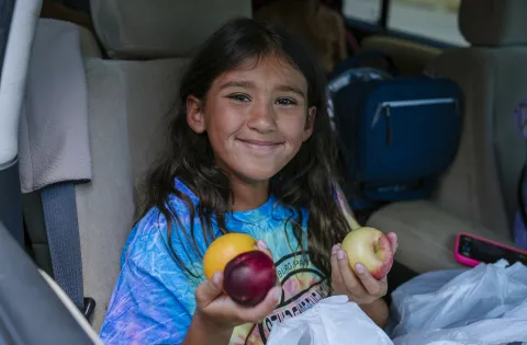 Smiling girl with fruit.